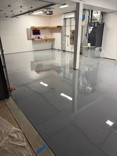Wide view of a gray epoxy coated garage floor showing the glossy finish and reflections